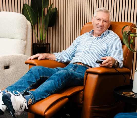 Smiling man reclining in a tan leather Posture Care recliner